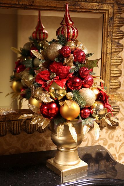 a red and gold Christmas tree composed of ornaments, gilded leaves and a shiny topper