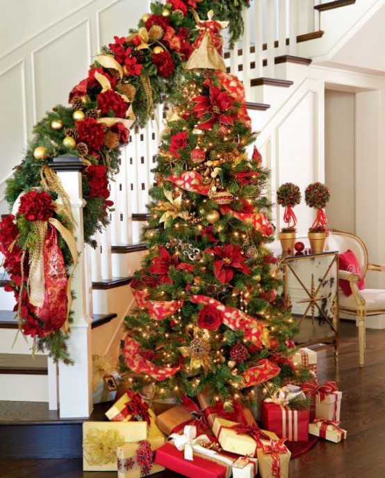 traditional gold and red Christmas decor - a Christmas tree with such decor and lights and railing decorated with evergreens, gold and red plus pinecones