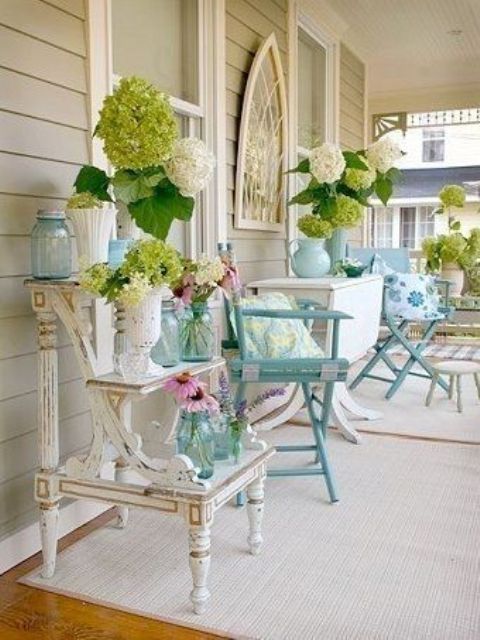 White and green blooms, foliage, blue jars and vases for a vintage inspired spring porch