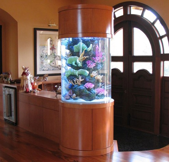 A round aquarium enclosed into rich stained wood makes a lovely decor feature and separates the entryway from the rest of the house