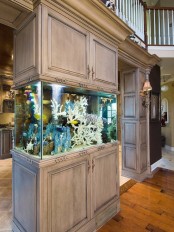 an aquarium enclosed into whitewashed wooden cabinets that can hold all the necessary stuff and fish food if there’s any fish