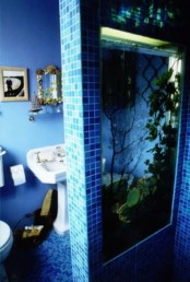 a built-in aquarium is a cool space divider for the shower space is a lovely idea to feel like in the sea