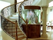 a foyer with an oversized aquarium with rich-stained wood perfectly matches the space and looks very catchy here