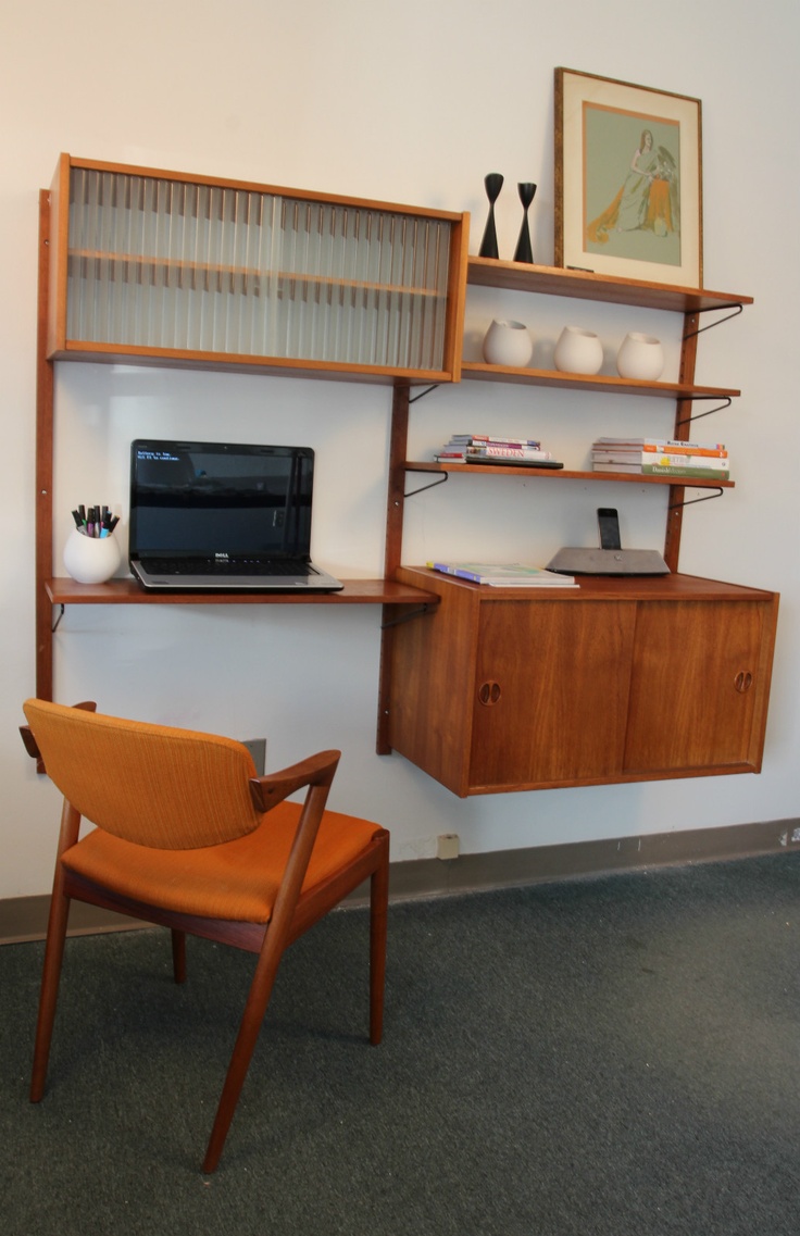 A floating wall mounted storage unit with a cabinet and some open shelves plus a desk incorporated