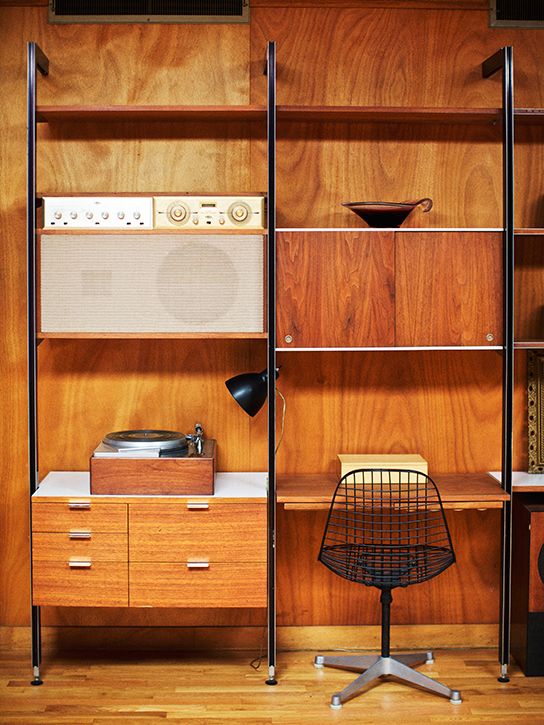 A large rich stained wall unit with closed storage compartments, drawers and open shelves plus a mini desk integrated