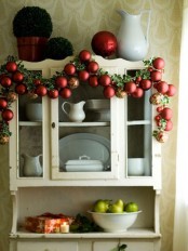 a holiday garland of colorful ornaments and foliage is a cool decoration for Christmas spaces – from kitchens to living rooms