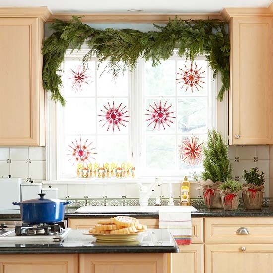 Hang decorative snowflakes in red tones and add an evergreen swag on top of the window.
