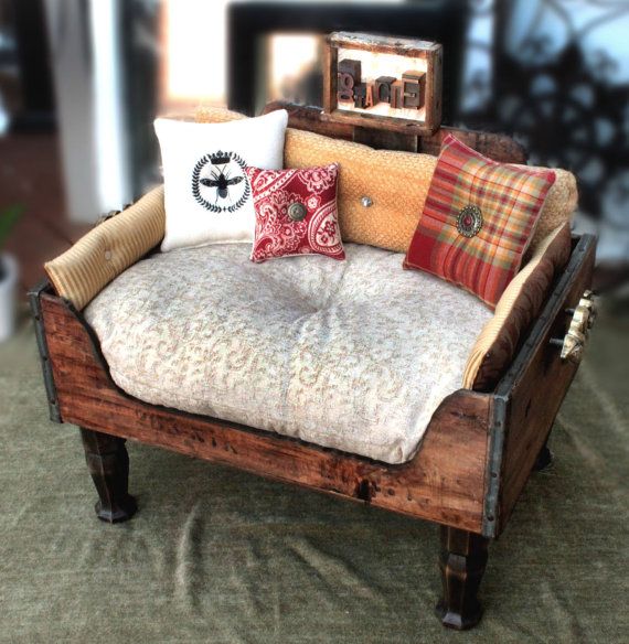 A rich stained drawer put on legs, with a cushion and some pillows is a lovely idea for a rustic home