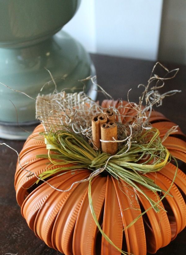 An orange pumpkin made of tin rings, hay, burlap, twine and cinnamon sticks is a stylish idea