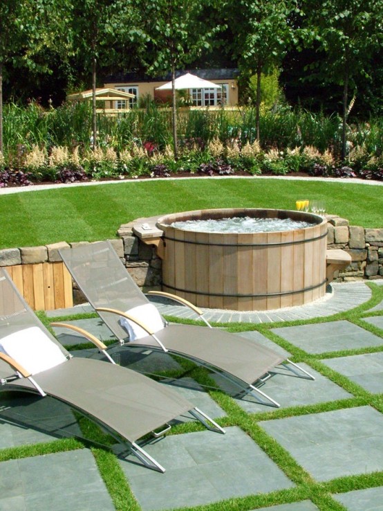Wooden hot tub that connects two lawn levels and looks like it is built-in.