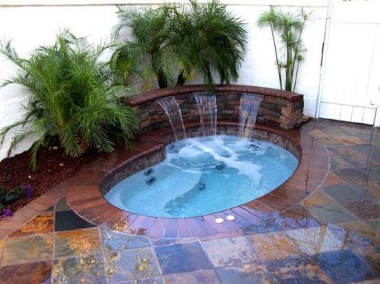 Combining a jaccuzzi with a backyard waterfall is definitely a cool way to go.