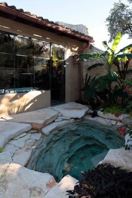 Natural stone garden tub design. Looks like it's a located in some cave.