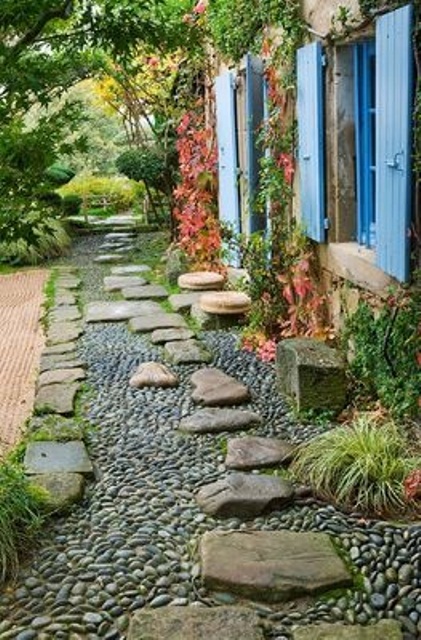 A black and grey gravel path with large rough stones on top that add eye catchiness and a bold touch to the space