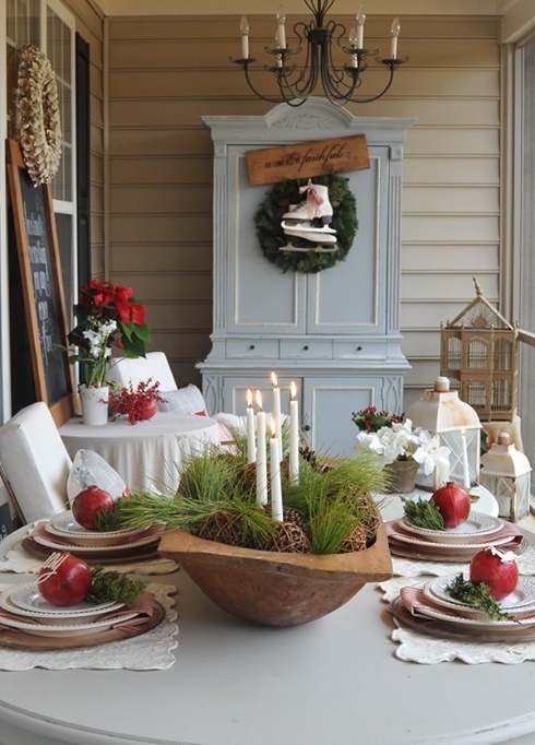 an elegant Christmas centerpiece of a dough bowl, greenery, vine balls and candles