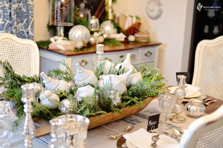 A winter centerpiece of a dough bowl, ferns and fir branches and white vintage Chhristmas ornaments