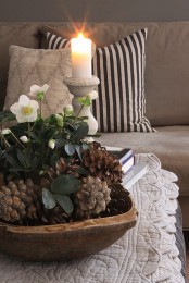 a simple and cute centerpiece with large pinecones and white blooms