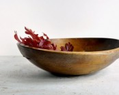 a dough bowl with some burgundy fall leaves is a minimal fall decoration