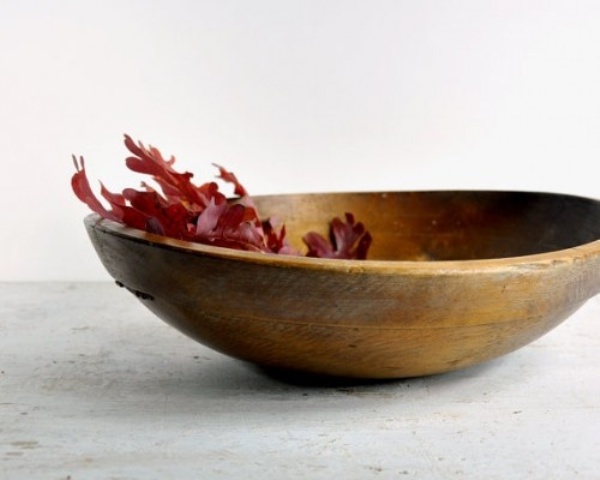 A dough bowl with some burgundy fall leaves is a minimal fall decoration