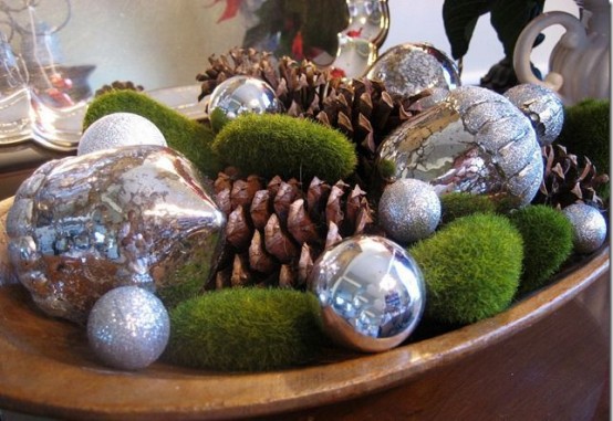 a dough bowl with moss balls, mercury glass Christmas ornaments and large pinecones