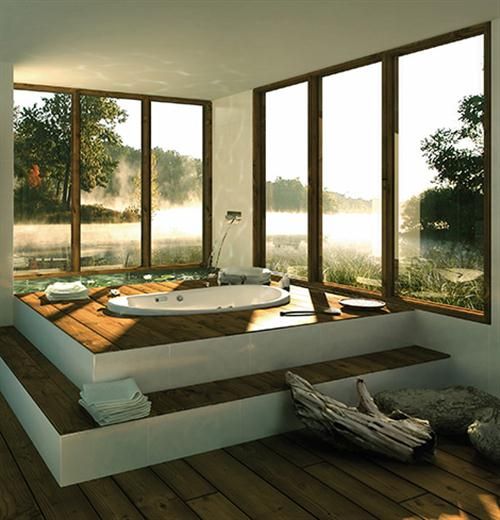 a stepped platform with a sunken tub by the windows makes it a real oasis of relaxation