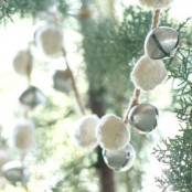 a garland of silver bells and white pompoms can be used on your Christmas tree or someewhere in your home for a chic holiday feel