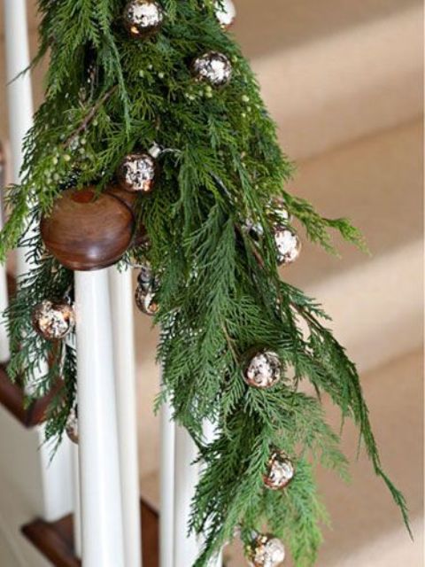 Railing decorated with fir branches and silver bells for Christmas   natural and traditional at the same time