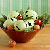a red bowl with oversized green bells, with apples and fir branches is a very cool and chic idea to rock