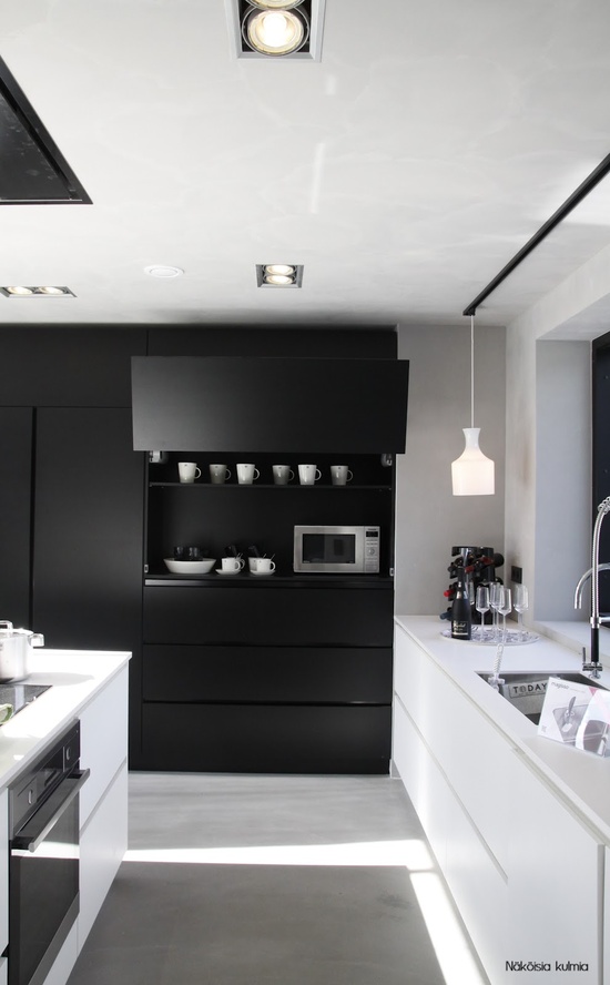 An ultra minimalist black and white kitchen with all sleek surfaces is a bold and contrasting idea for a modern person