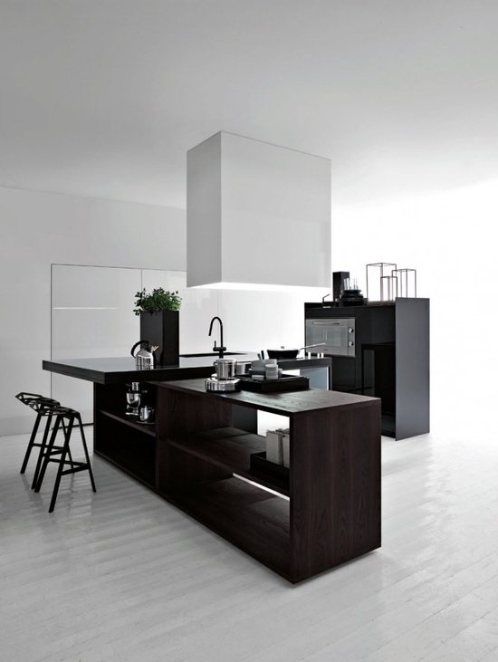 a contrasting minimalist kitchen with a dark kitchen island, a white sleek cabinet, a white hood and a black bar