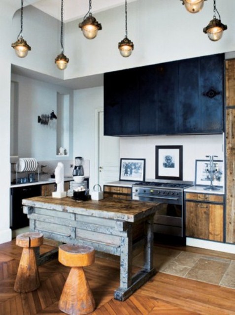 Light colored stained kitchen with black upper cabinets, pendant lamps, an industrial wood and metal kitchen island