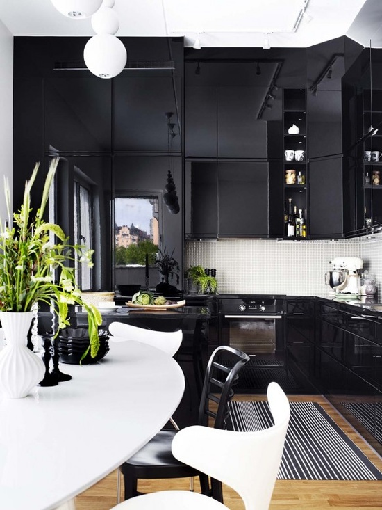 a refined black and white kitchen with dark cabinets, mini white tiles and ultra-modern chairs with sculptural shapes