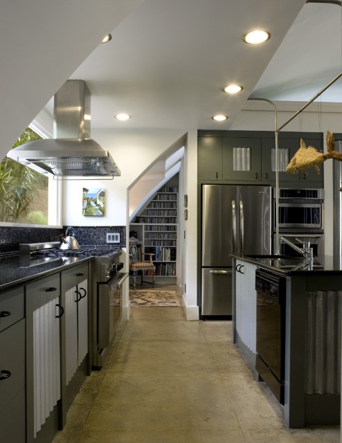A dark green kitchen with sleek cabinets, white corrugated steel touches and built in lights