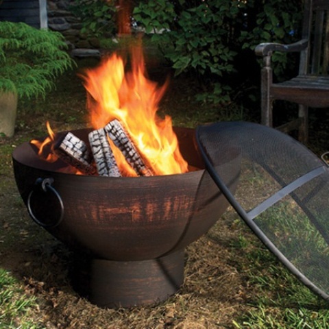 A blackened metal fire bowl with a spheric metal screen lid is a great idea for a modern outdoor space and it looks very eye catchy while being safe