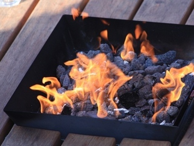 A tray like metal fire bowl with rocks inside is a timeless idea for any outdoor space, it will match any style easily