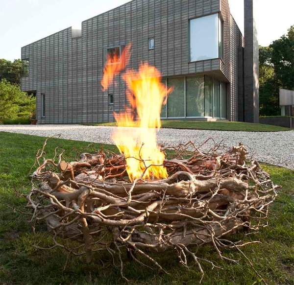 An alcohol working fire bowl surrounded with gilded branches as a nest is a bold installation for a modern outdoor space