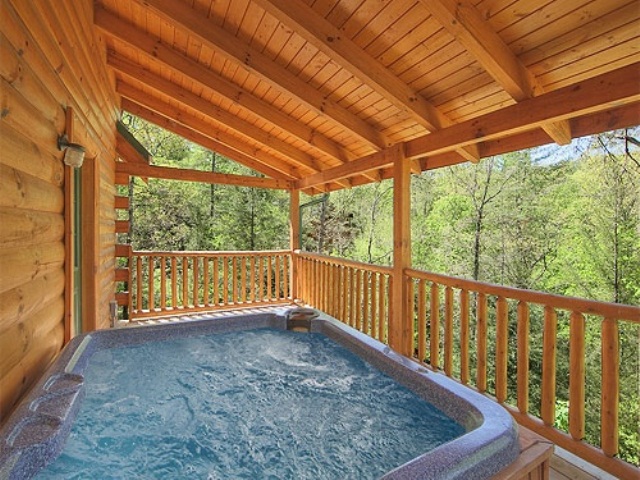 A deck with a built in outdoor jacuzzi and a view of the forest is a gorgeous space to relax in, it looks amazing