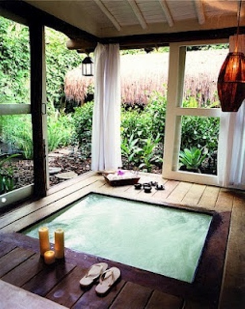 an outdoor-indoor jacuzzi in a small pavilion with sliding doors and a gorgeous garden view - as if you are bathing in the garden