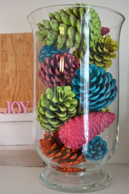 Spray painted pinecones really pop placed in a tall vase.