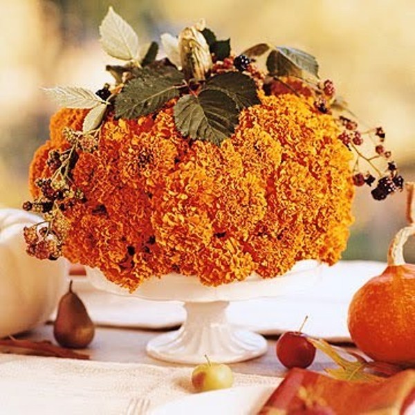 Cover the whole pumpkin with autumn blooms and put in on a cake stand. You'd only need to drill a bunch of holes in it.