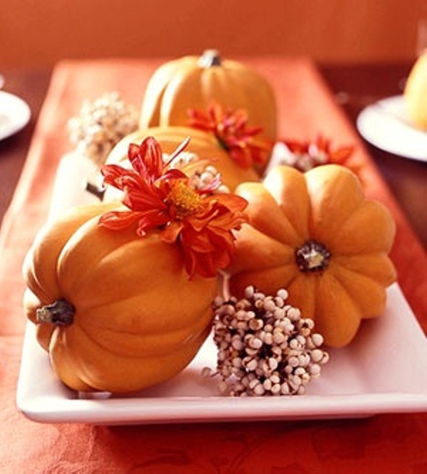Several small pumpkins mixed with fall blooms or fallen leaves could fit a single plate. Such centerpiece is easy to move around when necessary.