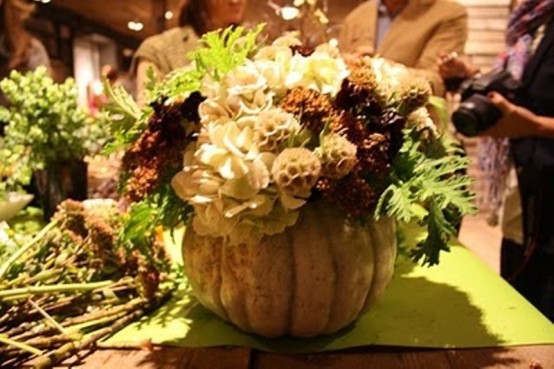 Hollow out the pumpkin, then place a of fall blooms and berries inside. That's all you need to do to make a natural piece of table decor.