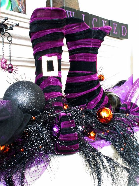 black and purple striped witches' stockings and boots, with black ornaments are a fun idea to style your mantel for Halloween