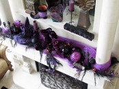 a bold purple and black Halloween mantel with pumpkins, witches’ legs and hats, candles, berries on branches and much other stuff