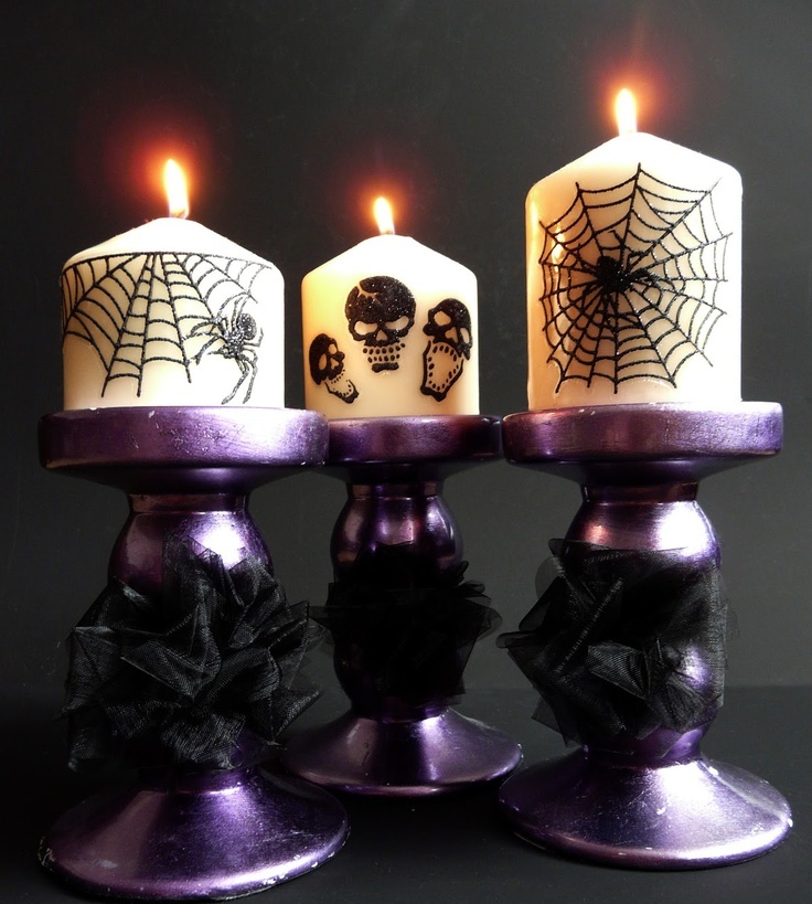 Purple candleholders, neutral candles with spiderwebs and skulls painted on them are amazing for Halloween styling
