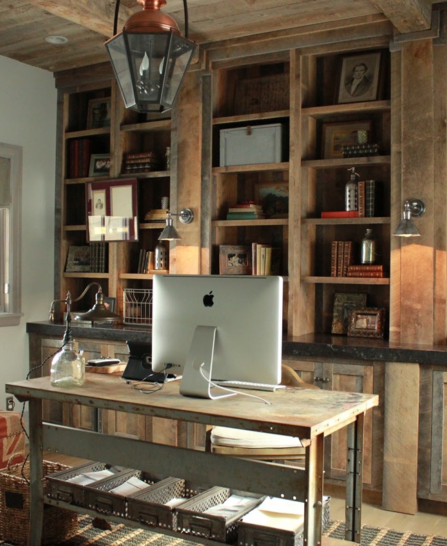 A rustic industrial home office with a large open storage unit, an industrial desk, a pendant vintage lamp and matching sconces on the shelving unit