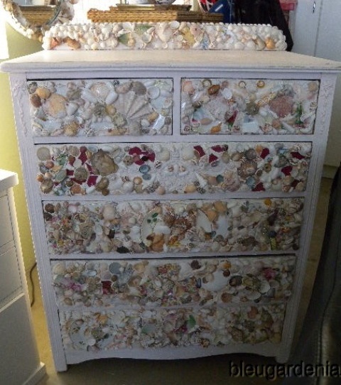a stylish white sideboard fully clad with seashells of various kinds looks very catchy and very chic