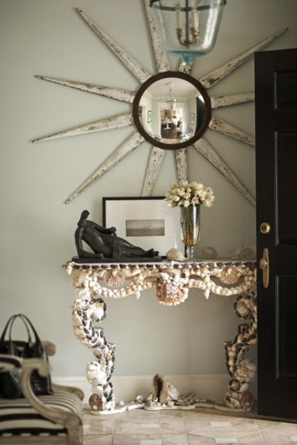 A refined vintage inspired console table clad with seashells and pebbles looks statement like and cool