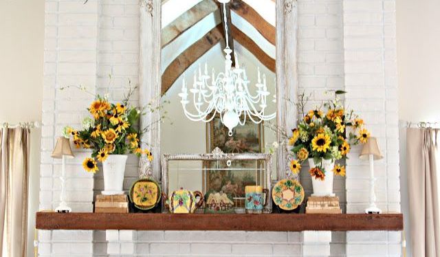 A rustic summer mantel with burlap lamps, vintage books, sunflowers and vintage teaware