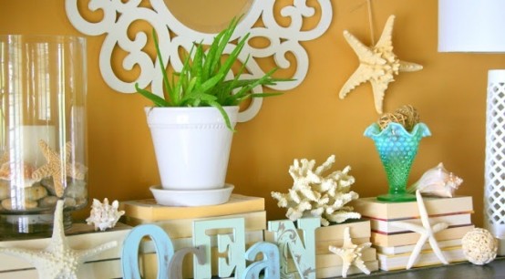 a beachy summer mantel with starfish, seashells, potted greenery and letters