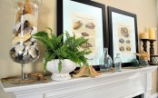 a beachy summer mantel with shell posters, candles, starfish, greenery and a jar with seashells